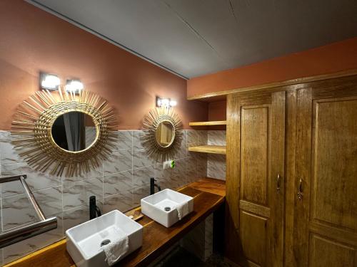 a bathroom with two sinks and a mirror at Mariama Lodge in Mbodiène