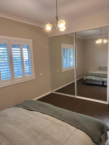 sypialnia z dużym lustrem i łóżkiem w obiekcie Family friendly Katoomba Cottage w mieście Katoomba