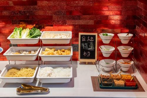 a display of food in trays on a table at Echarm PLUS International Hotel Zhujiang New Town Wuyangcun Metro Station Branch- Free Deliver Service to Canton Fair Complex During Canton Fair Period in Guangzhou