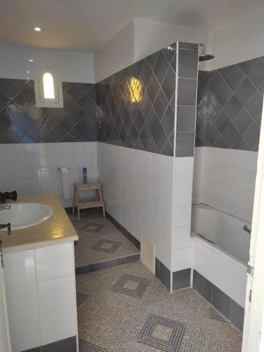 a bathroom with a sink and a bath tub at Villa Ulysse Djerba in Midoun