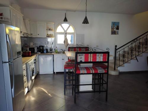 Villa Ulysse Djerba في ميدون: مطبخ مع ثلاجة وقمة كونتر