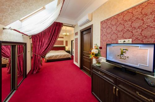 Habitación de hotel con TV y dormitorio. en Franz Hotel&Restaurant en Ivano-Frankivsk
