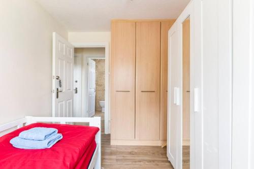 1 dormitorio con 1 cama con manta roja en Popular Easy Commute 20 mins from London Bridge and Gatwick Airport at Orpington Near to PRUH, en Farnborough