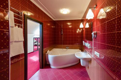 Baño rojo con bañera y lavamanos en Franz Hotel&Restaurant, en Ivano-Frankivsk