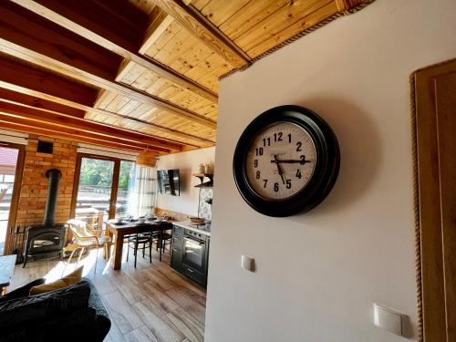 a clock on the wall of a living room at Dom nad jeziorem in Borowy Młyn