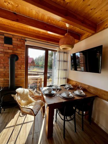 a dining room with a table and a fireplace at Dom nad jeziorem in Borowy Młyn