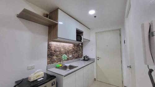 a small kitchen with a sink and a shower at 2P Cool Home Tagaytay at SMDC Cool Suite Residences in Tagaytay