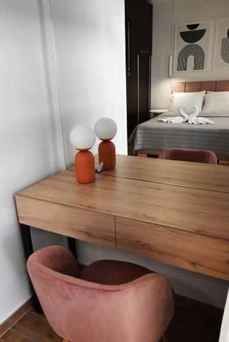 a room with a wooden table and a bed at Mouson Luxury Suite With Free Private Parking in Kavala