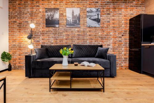 a living room with a couch and a brick wall at STAR Apartments Gdańsk - Gym & Sauna in Gdańsk