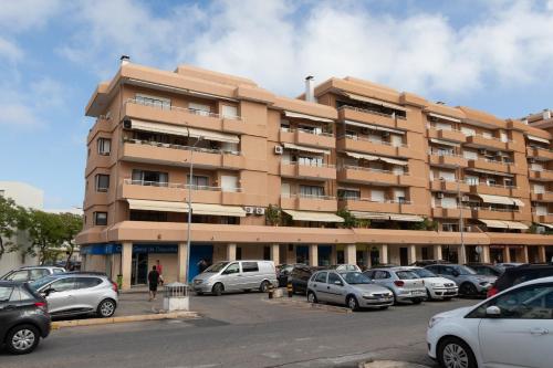 a large building with cars parked in a parking lot at BLife Ricardya private rooms in Faro