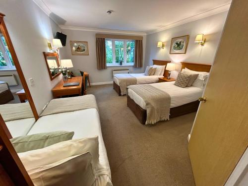 a hotel room with two beds and a window at New Forest Lodge in Landford
