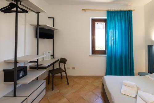 a hotel room with a bed and a desk and a window at Resort Santa Maria Hotel in Birgi Vecchi