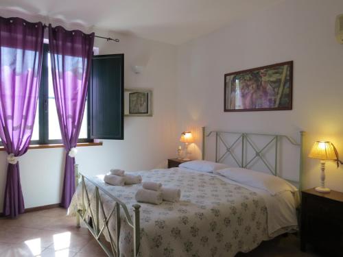 ein Schlafzimmer mit einem großen Bett mit lila Vorhängen in der Unterkunft L'Orto in San Vero Milis