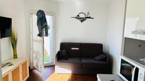 a living room with a couch and a window at Studio Saint-Cyprien Port in Saint-Cyprien