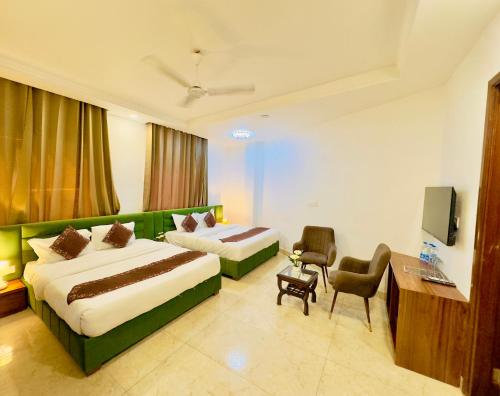 a hotel room with two beds and a television at Hotel La Casa Amritsar Near ISBT & Golden Temple in Amritsar