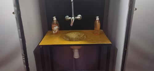 a bathroom with a sink and two bottles on a counter at Mustapha Camp Merzouga in Merzouga