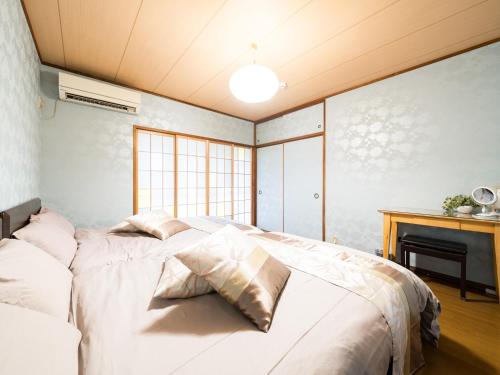 1 dormitorio con cama blanca y chimenea en Shinjuku/Okubo sta, 3 min walk/switch/board game/65㎡２LDK, en Tokio