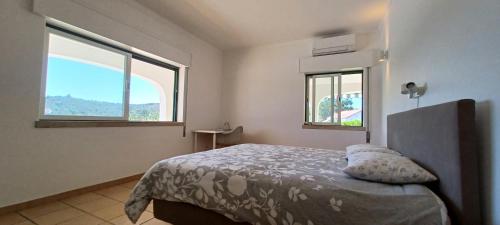 een slaapkamer met een bed en twee ramen bij Superbe Villa - piscine privée in Silves