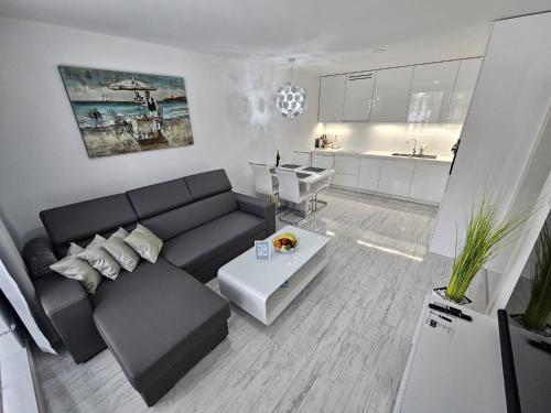 a living room with a black couch and a kitchen at Apartmány Urban in Poprad