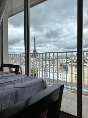 una camera da letto con vista sulla torre Eiffel di Tour Eiffel - Paris a Parigi