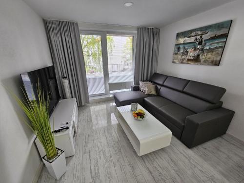 a living room with a black couch and a table at Apartmány Urban in Poprad