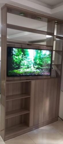 a flat screen tv sitting in a entertainment center at Adan Beach appartment in front of Atlantic in Aourir