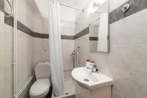 een witte badkamer met een toilet en een wastafel bij Evangelia cozy apartment in Agios Nikolaos