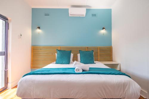 a bedroom with a large bed with blue accents at Zuri Place in East London