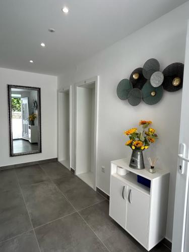 a hallway with a mirror and a vase of flowers at Apartments Emilija in Brela