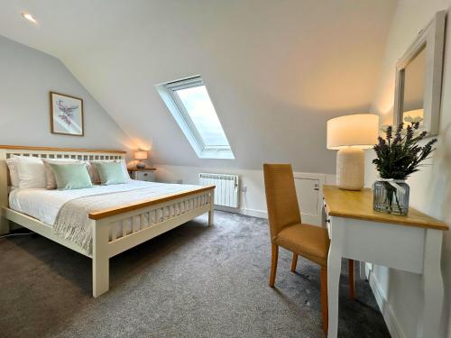 a bedroom with a bed and a desk and a chair at New Forest Lodge in Landford