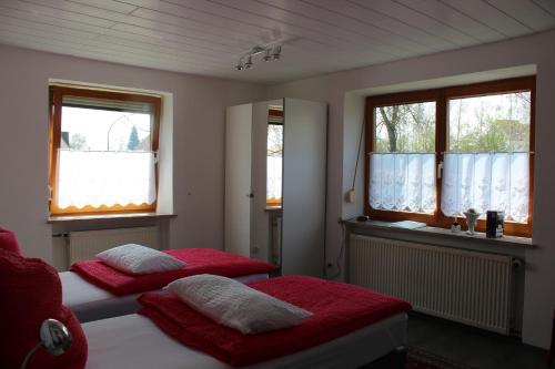 two beds in a room with two windows at Gästehaus Nicole in Burgau