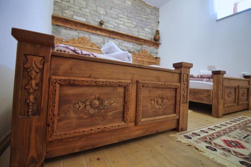 a bedroom with two wooden beds in a room at Guri Guesthouse in Gjirokastër