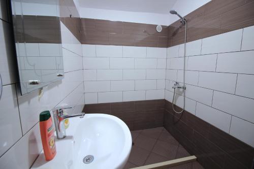 a bathroom with a white sink and a shower at Guri Guesthouse in Gjirokastër