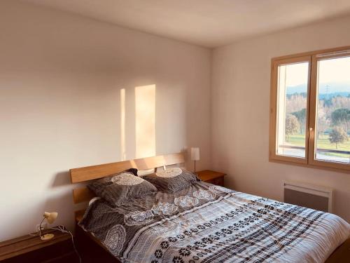 une chambre avec un lit avec une grande fenêtre dans l'établissement Charmante maison de vacances en Luberon, à Beaumettes