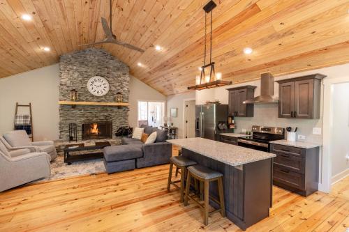 a kitchen and living room with a stone fireplace at Hemlock Hideaway in Ellijay