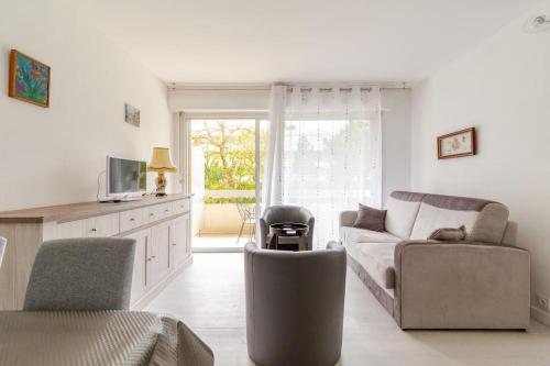 un salon avec un canapé et une chaise dans l'établissement Escapade lumineuse au calme à proximité de la Plage Benoît de La Baule, à La Baule