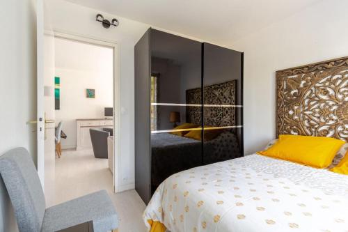 - une chambre avec un grand lit et une tête de lit jaune dans l'établissement Escapade lumineuse au calme à proximité de la Plage Benoît de La Baule, à La Baule