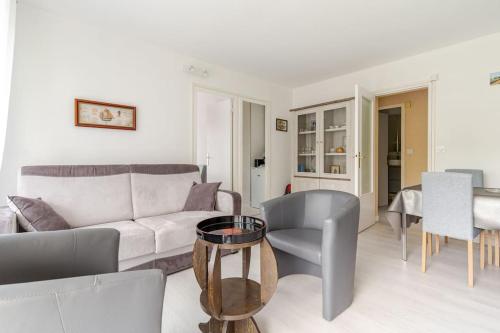 a living room with a couch and a table at Appartement Lumineux avec parking privé à proximité de la Plage Benoît de La Baule in La Baule