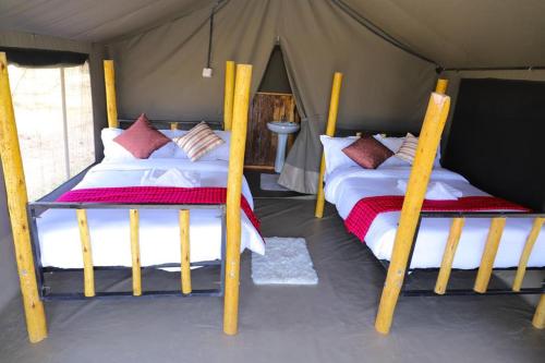 a couple of beds in a tent at Emunyan maasai Mara camp in Sekenani