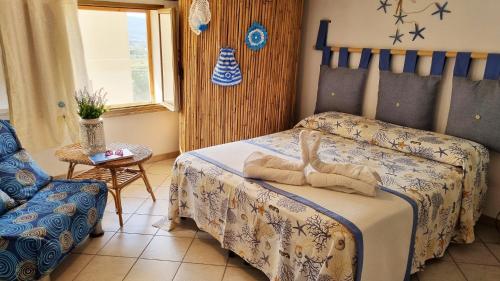 クストナーチにあるCasa Vacanza Vista Mareのベッドルーム1室(ベッド1台、椅子付)