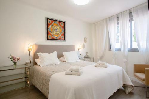 - une chambre blanche avec un lit blanc et 2 serviettes dans l'établissement Great Apartment with huge terrace in Mijas Pueblo, à Mijas