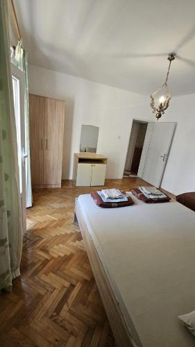 a bedroom with a bed and a wooden floor at Radenović, soba in Budva