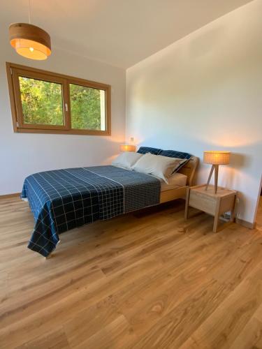 a bedroom with a bed and a table and a window at Maison Olivier in Veigy-Foncenex