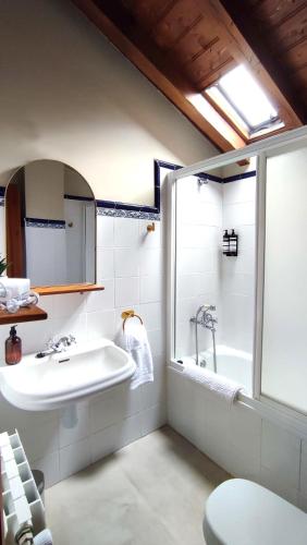 a bathroom with a sink and a tub and a toilet at Posada La Dalia in Castillo-Pedroso