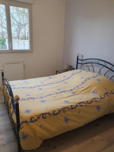 un lit avec une couette jaune dans une chambre dans l'établissement Location les Bruyères, à Saint-Germain-sur-Ay
