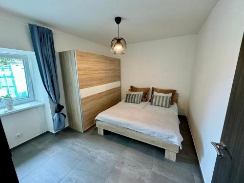 um pequeno quarto com uma cama e uma janela em Byt 71m2 klid pohoda a příroda em Praga