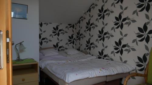 a bedroom with a bed with a black and white wallpaper at Dom we Fromborku in Frombork