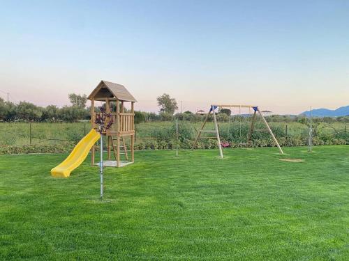a playground with two swings and a slide at La Familia Luxury Private Maisonettes near the sea in Gythio