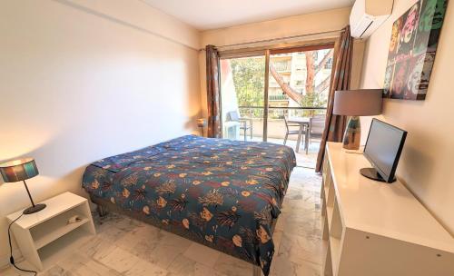 une chambre avec un lit et un bureau avec une télévision dans l'établissement LACOUR7 Palmes dProperties, à Cannes