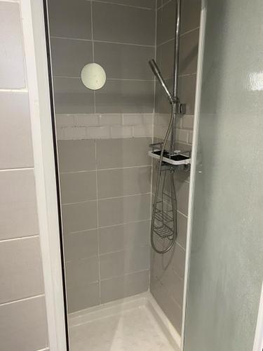 La salle de bains est pourvue d'une douche avec une porte en verre. dans l'établissement Chambre chez CyriLydie, à Clichy-sous-Bois